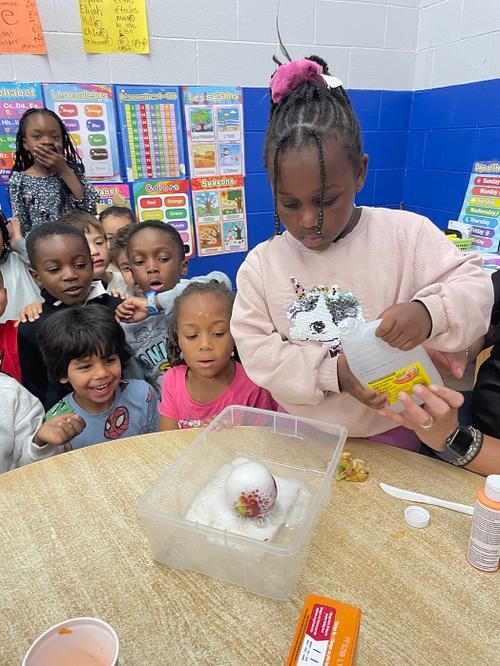Petit groupe d'élèves de maternelle 5 ans observant avec curiosité une expérience de sciences
