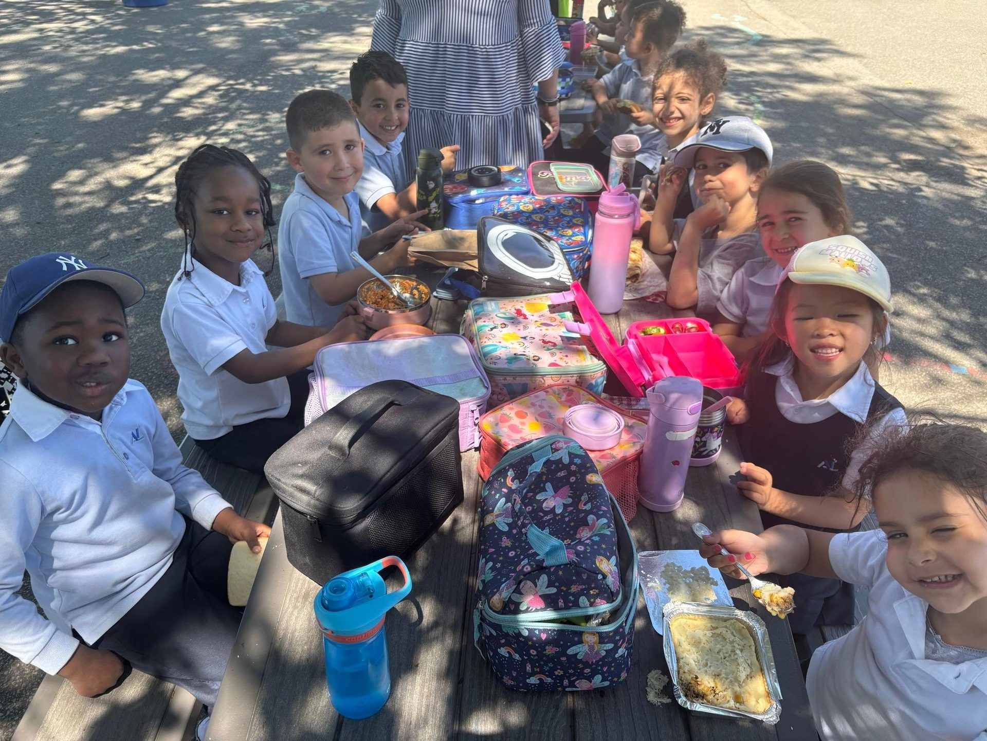 Élèves de l'Académie Lavalloise dînant ensemble à une table de pique-nique, dehors