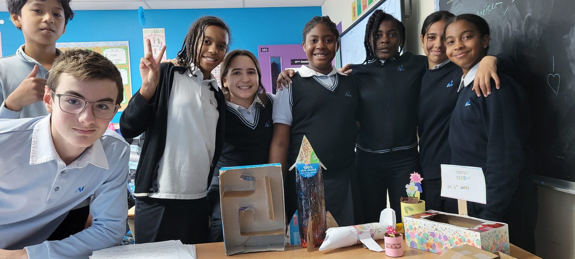 Groupe d'élèves de l'Académie Lavalloise en uniforme, souriants autour de leurs projets